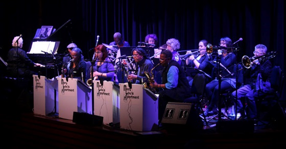 photo of the ensemble playing on stage in a darkly lit concert hall