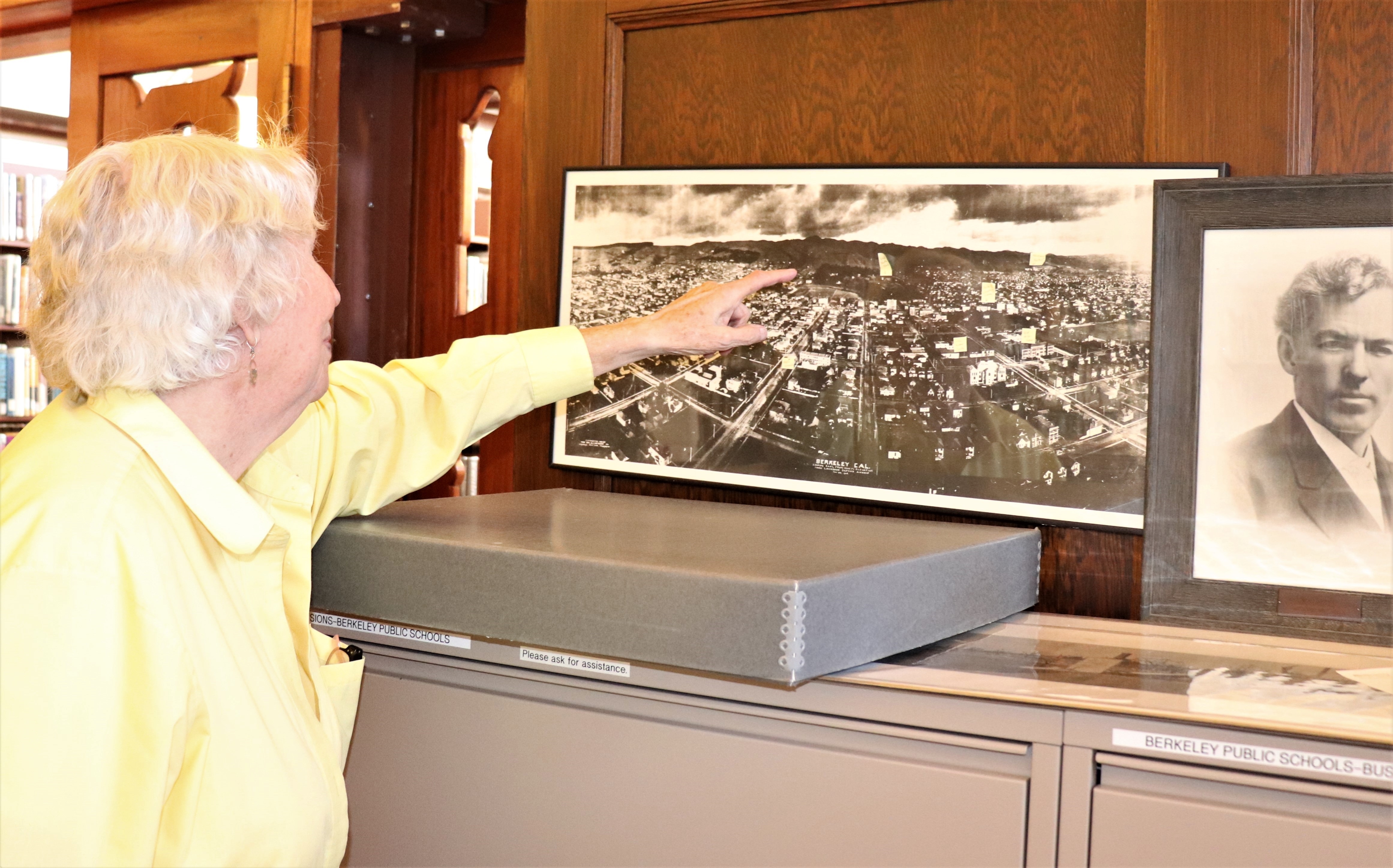 pic of patron pointing out where she grew up on an old map of Berkeley 