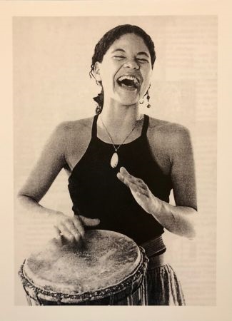 Amber Hines smiling and playing a drum