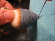 hand with needle felting materials