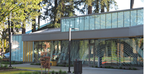 The front of the Shute Park branch, a glass-fronted building surrounded by trees.