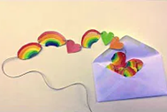 A string of paper rainbows and hearts lies half-out of an envelope.