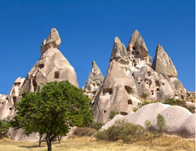 The windows of these homes peer out from their roughly conical rock formation exteriors.