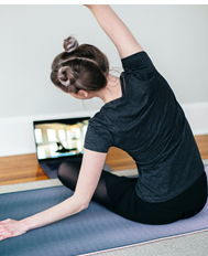 A person follows along with a virtual yoga class.