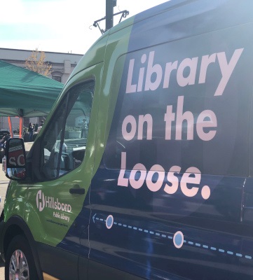 A green and blue van with "Library on the Loose" written on the side in large letters.