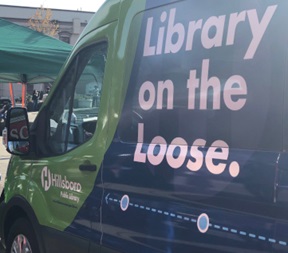 A green and blue van with "Library on the Loose" written on the side in large letters.