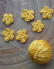 ball of yarn and crocheted flowers