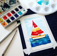 A sailboat painting and the watercolors and brushes used to paint it.