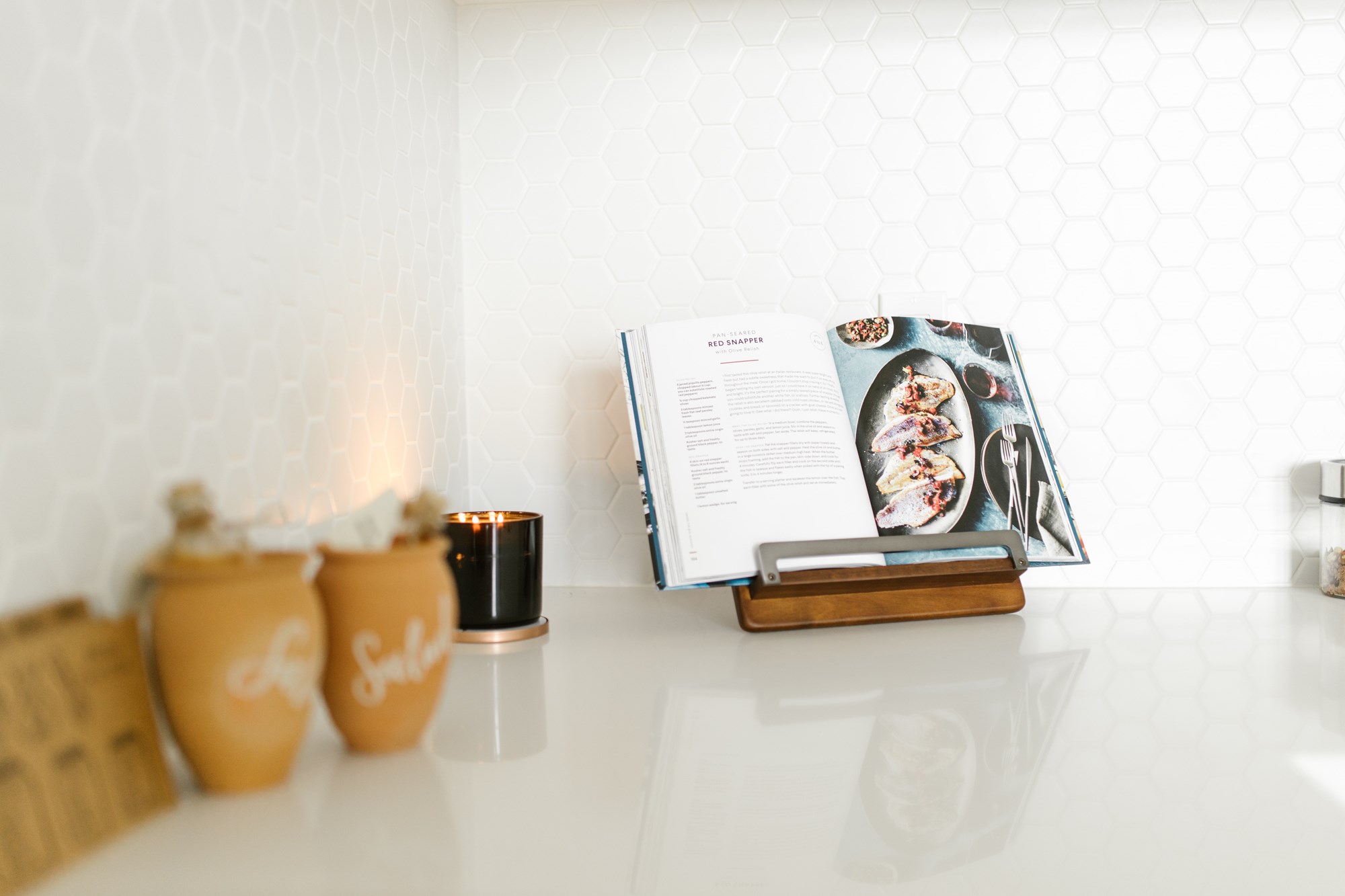 Open Cookbook on Kitchen Counter with Jars
