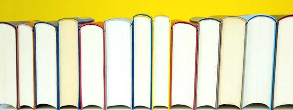 Books Lined Up on Yellow Background
