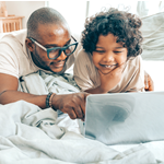 Father and Child Using Laptop Together
