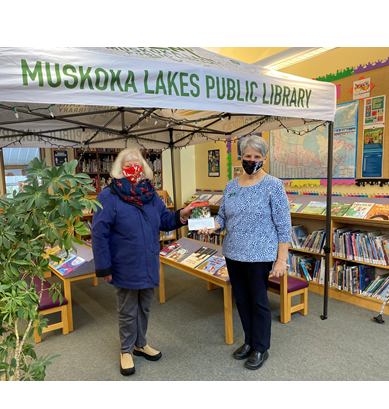 Liz Denyars presents a cheque, on behalf of the Muskoka Ratepayers' Association, the Muskoka Lakes Public Library's CEO, Cathy Duck.