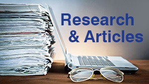 Laptop computer and stack of journals and magazines