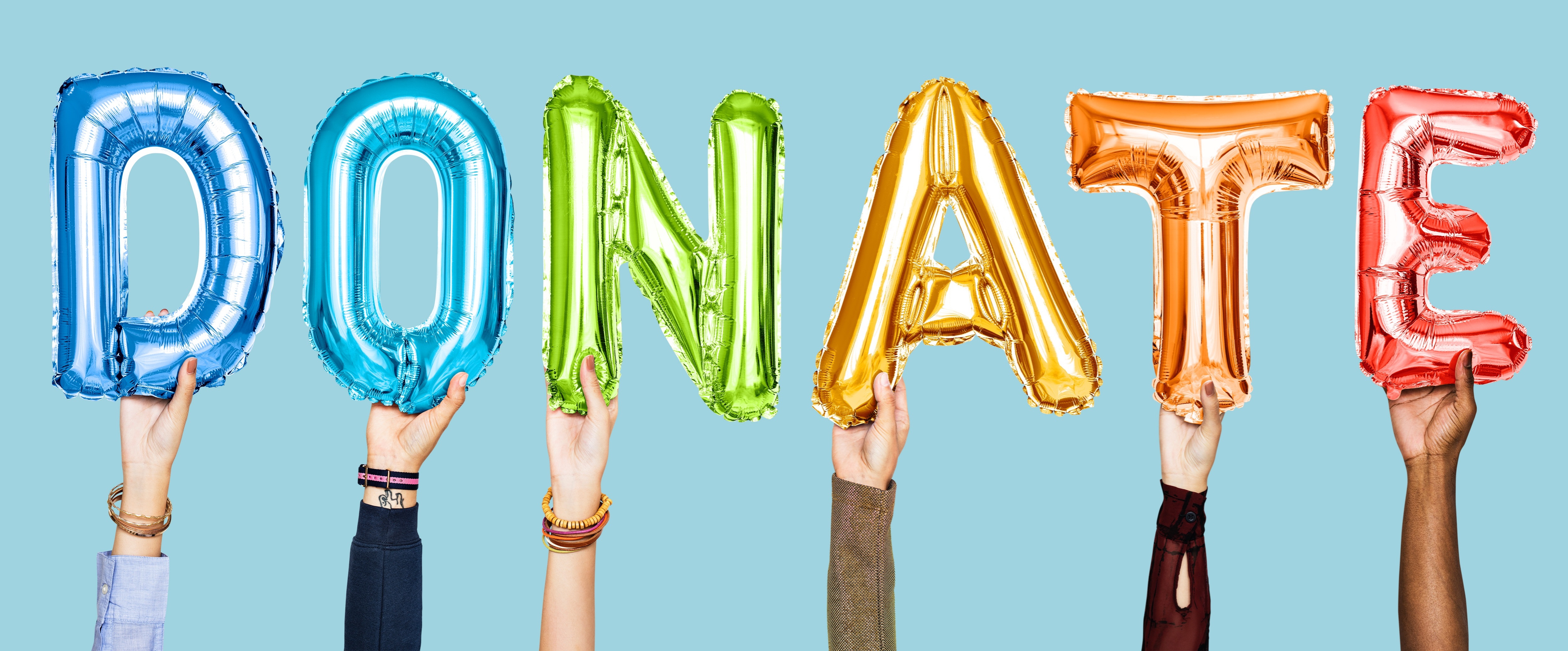 Image of hands holding colored balloons that spell the word "donate"