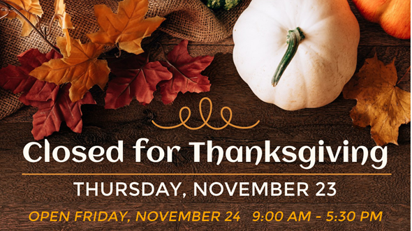 Assorted colored leaves and a white pumpkin on a table above text "Closed for Thanksgiving Thursday, November 24."