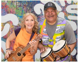 Picture of musicians Wendy and DB. Wendy is holding a ukulele and DB is holding bongo drums.