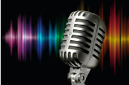 Microphone in front of a black background with a rainbow spectrum of colored light streaks