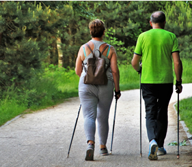 A woman and man walking together outdoors with walking sticks