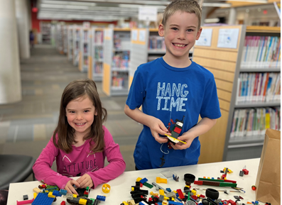Two kids at a table doing LEGO inside the Bradford Library