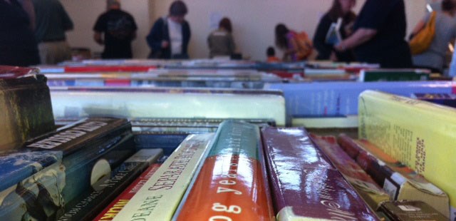 A photo of people browsing books at a sale.