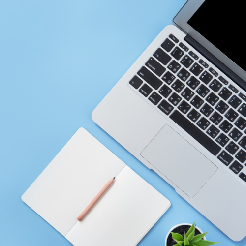 Laptop and note pad and pencil on blue background