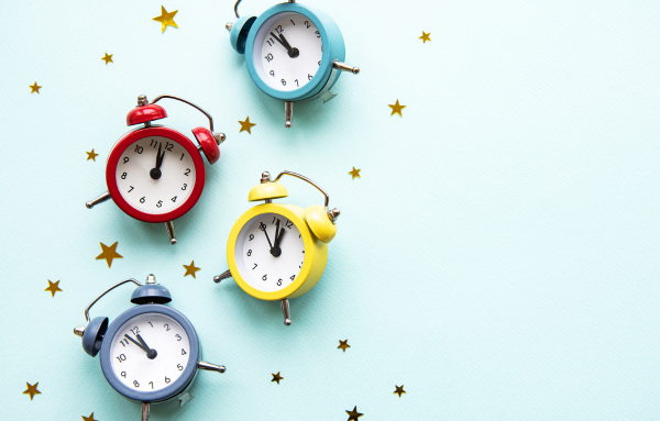 4 colorful alarm clocks and gold star confetti