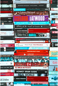 image of stacked paperback book spines mostly in red and blue