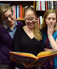 Image of Rebecca, Autumn, and Lindsey reading a picture book