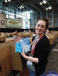 NextReads librarian Lisa adding books to a box in the BookExpo shipping room