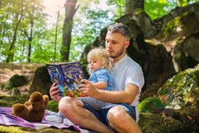 Adult reading to child outside