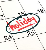 Closeup of a calendar with "holiday" written on the 25th.