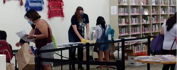 Youth Services Librarian Katie helps families pick out school supplies.