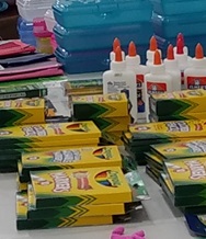 A closeup photo of school supplies such as glue and markers.