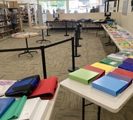 Tables full of school supplies such as binders and notebooks.