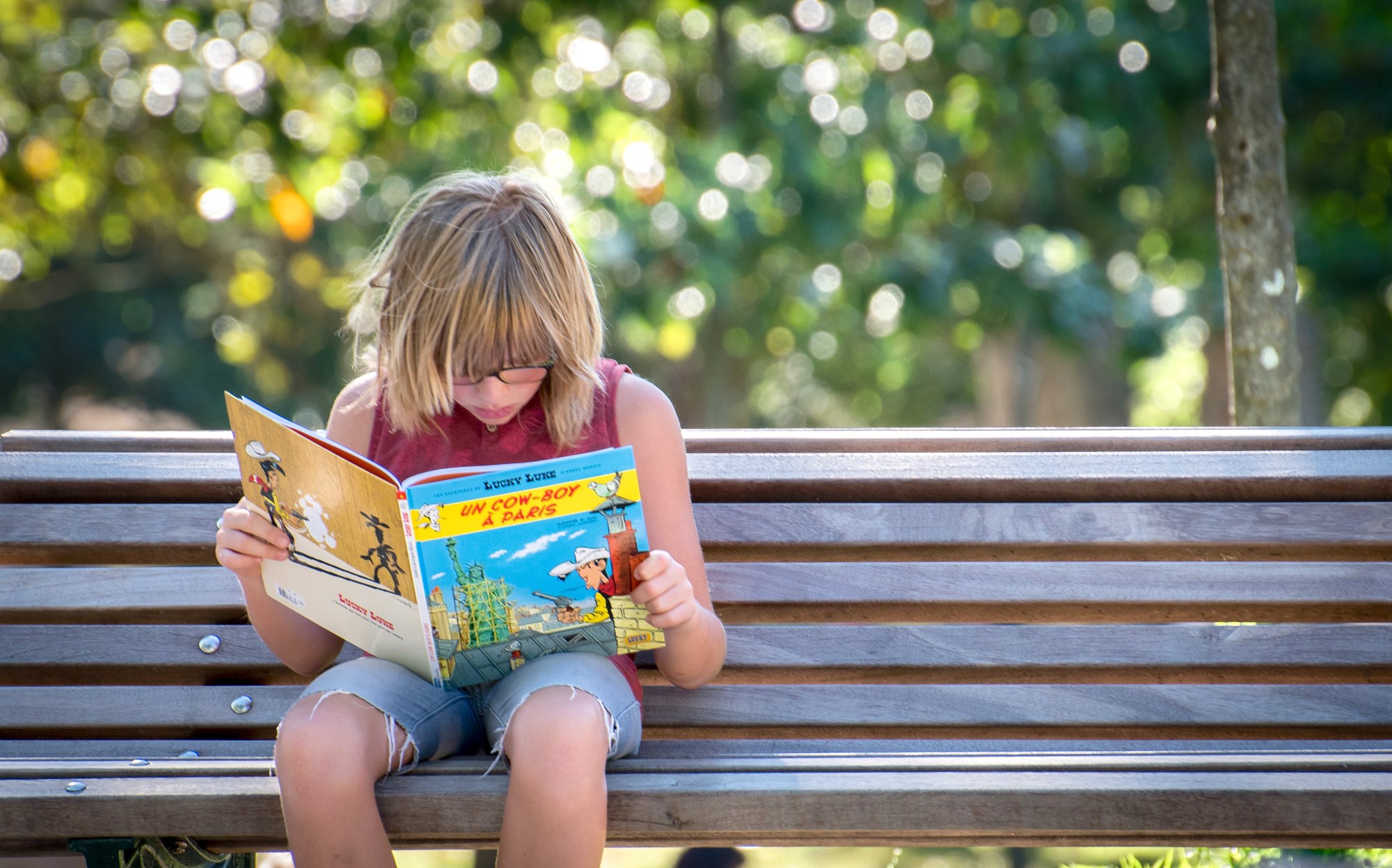 child reading on park bench