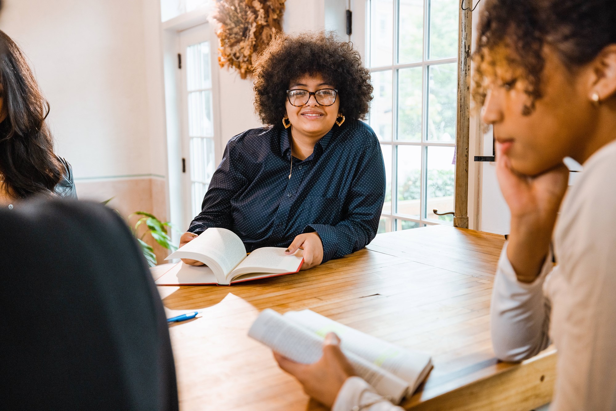 group of adults sitting discussing a book