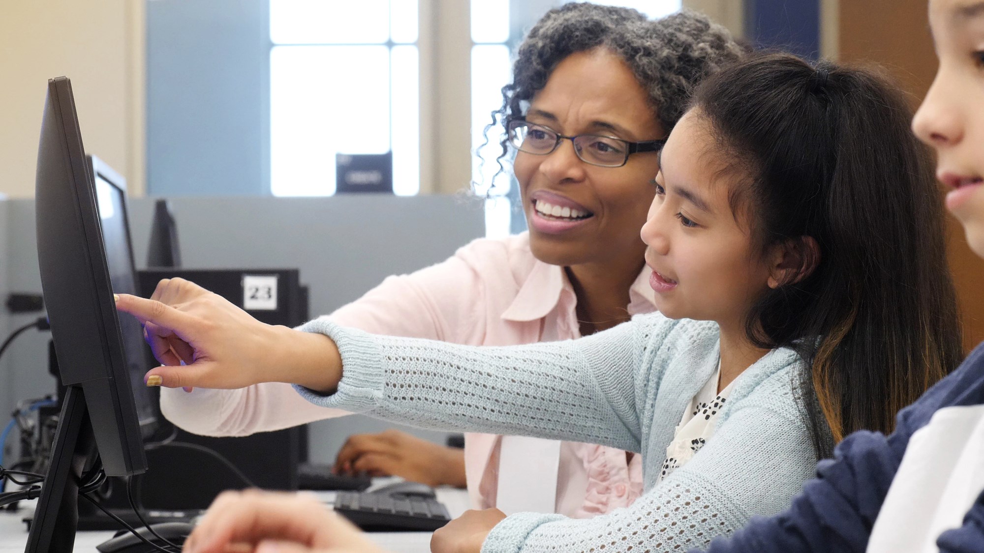 librarian helping child with the computer