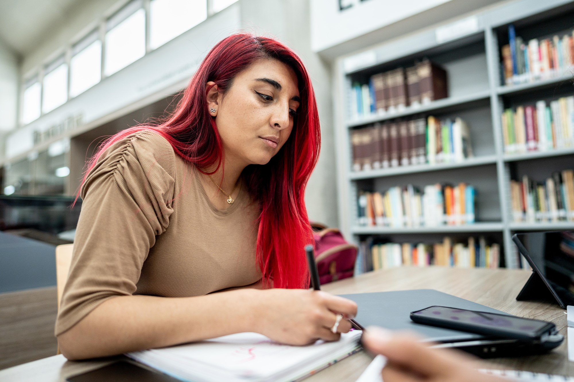 Woman with Red Hair Writing in a Notebook