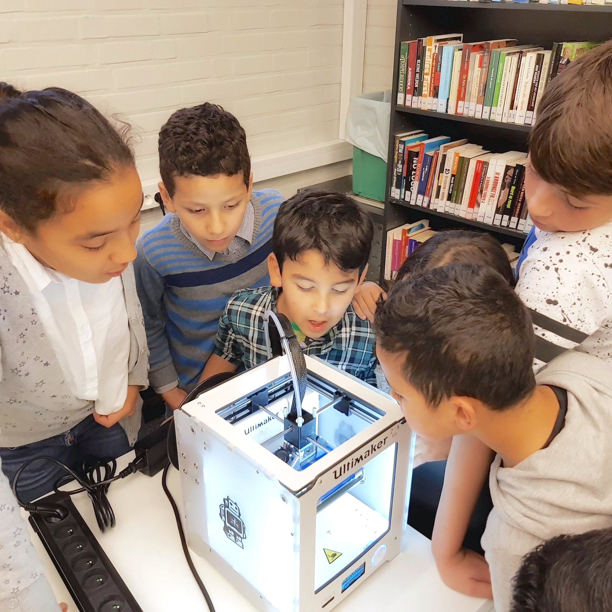 children watching a 3D printer