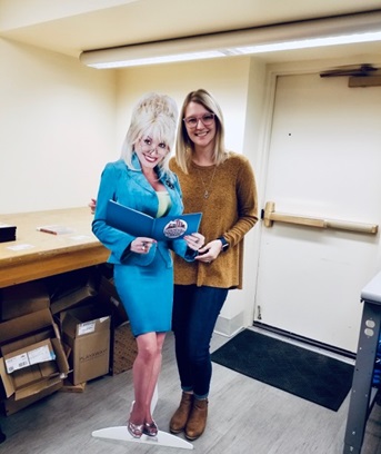 Heather from ACPL poses with a cutout of Dolly Parton.