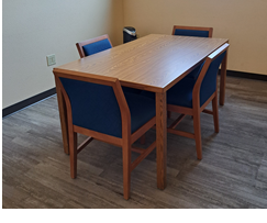 A study room with a table surrounded by 4 padded chairs and a HEPA air purifier in the corner.