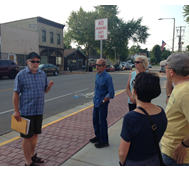 Picture of Ron Larson leading a walking history tour on Main Street in front of the library.