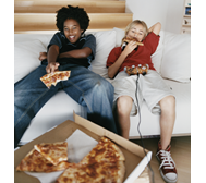 Picture of two teens eating pizza and playing video games