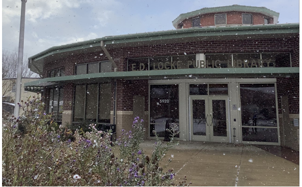 A picture of E.D. Locke Public Library with snow falling.