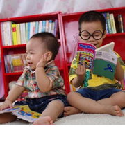 Two toddlers reading.