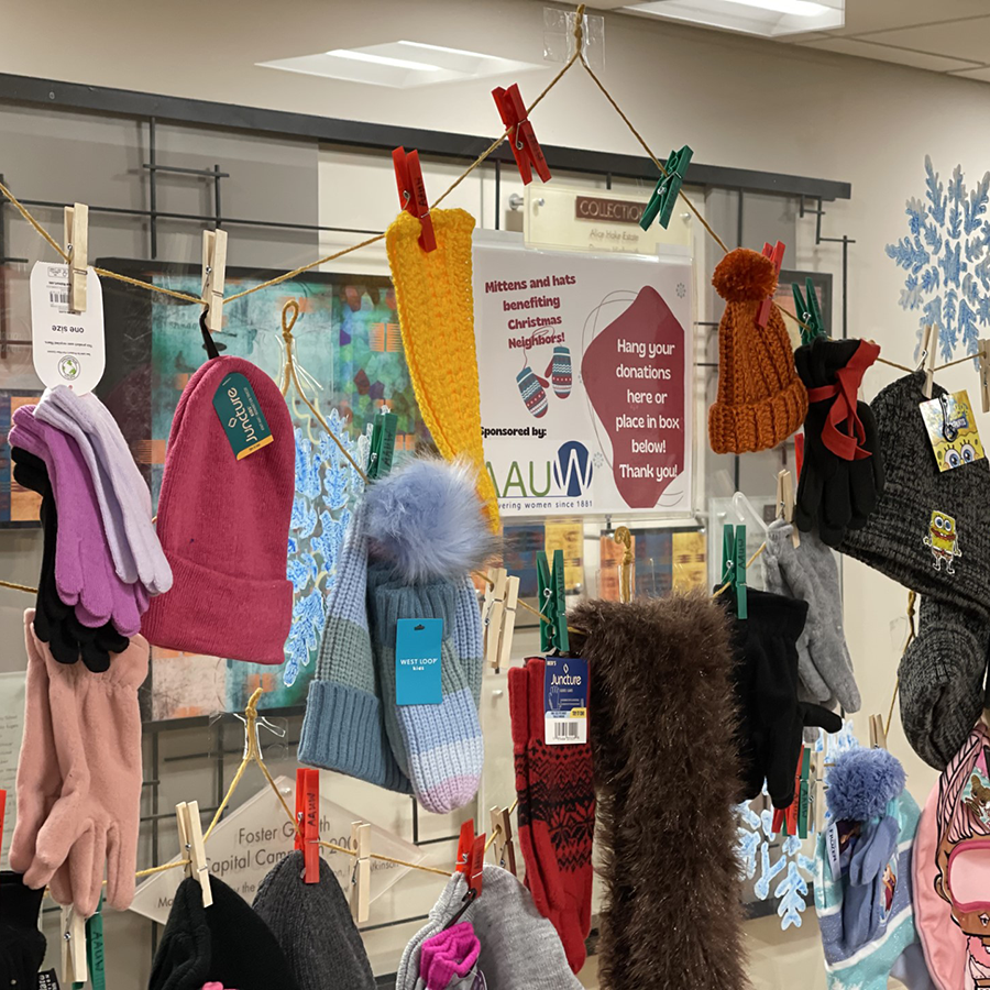 Photo of a clothesline with hats, gloves and mittens attached inside the library.