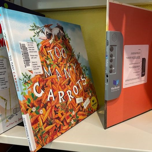 Photo of a Vox book titled, "Too Many Carrots," on a book shelf. 