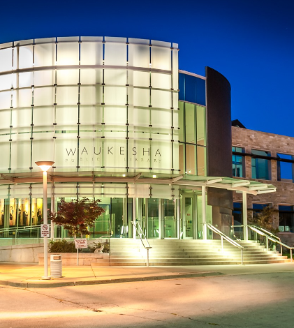 Photo of the exterior of the Waukesha Public Library at night.