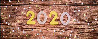 Photo of the numbers 2020 laying on a wooden surface with confetti.