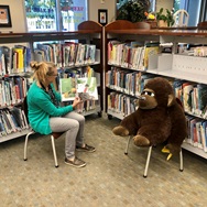 Librarian reading to a gorilla plush